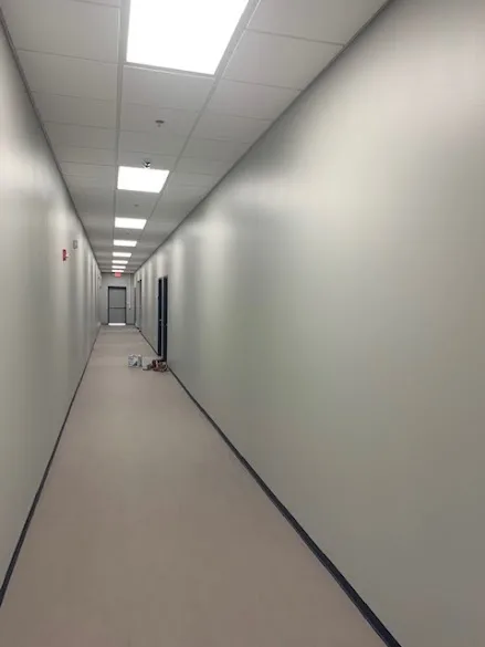 Long commercial hallway with freshly painted walls and dark baseboards in an Oklahoma City building