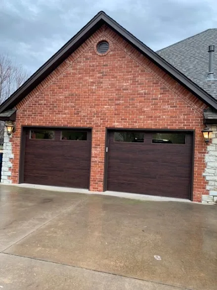 Brick home with two freshly painted dark brown garage doors and trim in the Oklahoma City area