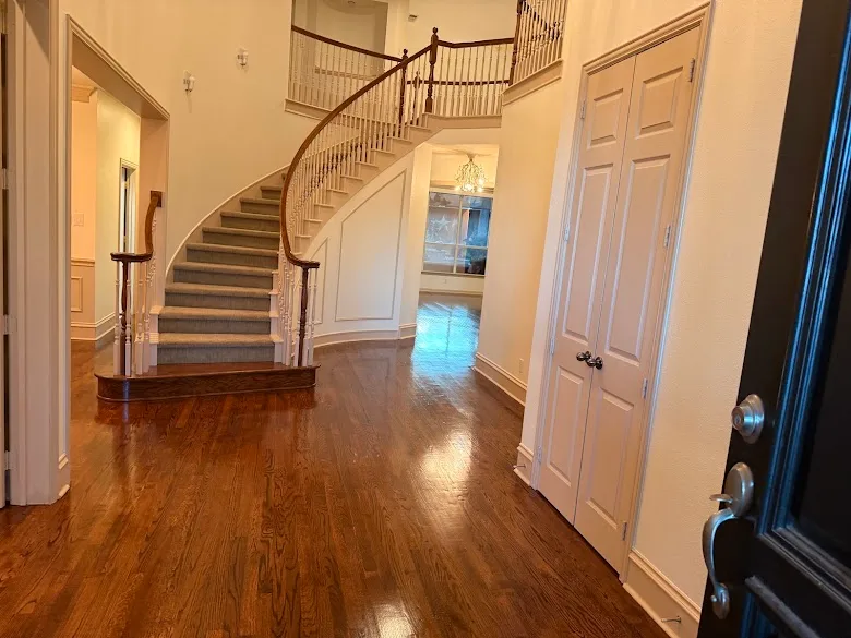 Curved staircase and entry hall with freshly painted walls and white trim, painted by GG Painting & Drywall